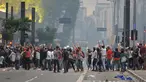 Mahasiswa bentrok dengan polisi saat memprotes kenaikan tarif bus di Sao Paulo, Brasil, Selasa (12/1). Mereka protes karena di tengah krisis ekonomi yang ditandai dan inflasi tinggi, tarif transportasi angkutan bus justru naik. (AFP PHOTO/NELSON Almeida)