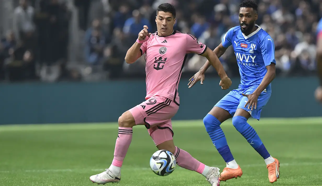 Pemain Inter Miami, Luis Suares (kiri) berebut bola dengan pemain Al-Hilal saat laga persahabatan yang berlangsung di Kingdom Arena Stadium, Riyadh, Arab Saudi, Selasa (30/01/2024) WIB. Keputusan golnya tersebut berubah setelah meneninjau VAR. Bola yang awalnya dikira merupakan umpan dari Julian Gressel ternyata tersentuh kaki pemain Al-Hilal, Mohammed Jahfali. (AP Photo)