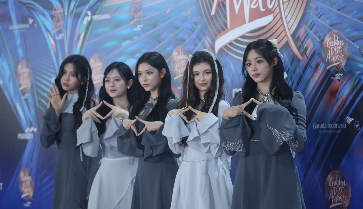 Lalu, Hanni mengenakan hair clip pita putih pada rambut panjang wave belah pinggir. Serta, Danielle dengan gaya rambut tampil cantik dengan gaya rambut wave ditambah hiasan pita. Mereka berlima pun tampil dengan makeup flawless glowing. [Foto: Bayu Herdianto/Fimela]