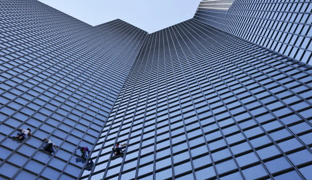 <p>Pendaki Alain Robert (kedua kanan) atau Spiderman Prancis bersama Marcin Banot, Alexis Landot, dan Leo Urban memanjat Menara Total di La Defense, Paris, Prancis, 7 September 2021. Alain dengan tangan kosong memanjat menara setinggi 190 meter itu untuk menentang izin kesehatan. (THOMAS SAMSON/AFP)</p>