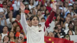 Pebulu tangkis Indonesia, Gregoria Mariska Tunjung memberi aplaus kepada penonton dari atas podium untuk menerima pengalungan medali perunggu nomor tunggal putri cabor bulu tangkis Olimpiade Paris 2024 saat upacara penyerahan medali di Porte de La Chapelle Arena, Paris, Senin (5/8/2024). (AP Photo/Kin Cheung)