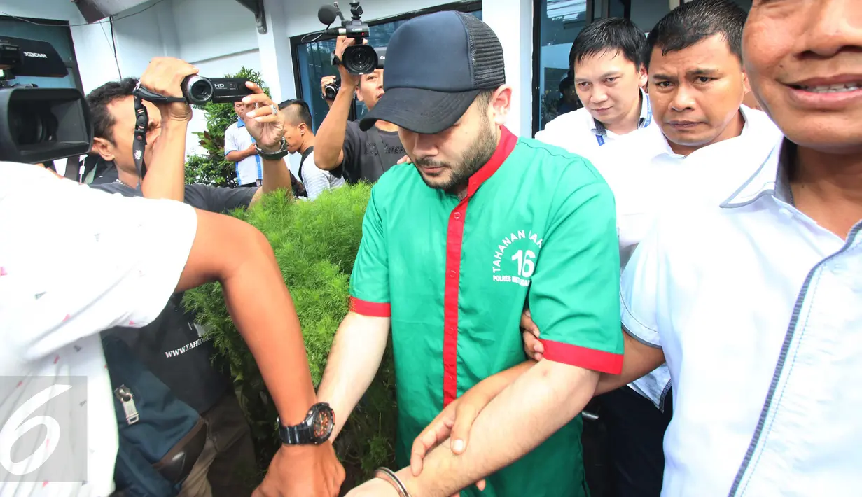 Penyanyi dangdut Ridho Rhoma dibawa petugas usai menjalani pemeriksaan di BNN, Jakarta, Kamis (30/3). Ridho Rhoma ditangkap polisi pada Sabtu (25/3) pukul 04.00 WIB. Polisi menemukan sabu seberat 0,7 gram di mobilnya. (Liputan6.com/Gempur M. Surya)