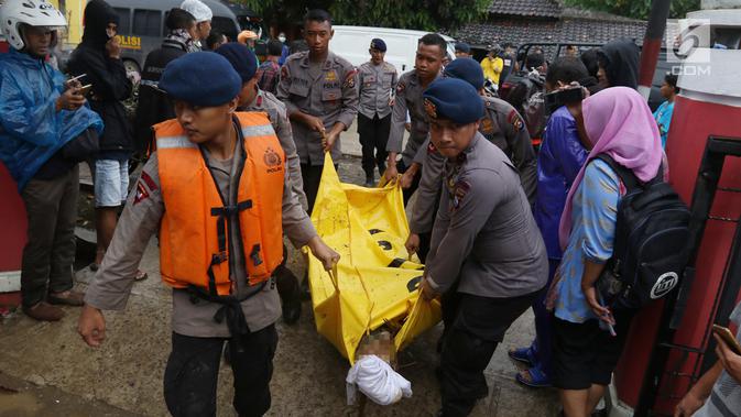 Polisi mengevakuasi jenazah korban gelombang Tsunami Anyer di Puskesmas Carita, Banten, Minggu (23/12). BNPB mencatat ratusan orang meninggal dunia dan ratusan luka-luka. (Liputan6.com/Angga Yuniar)