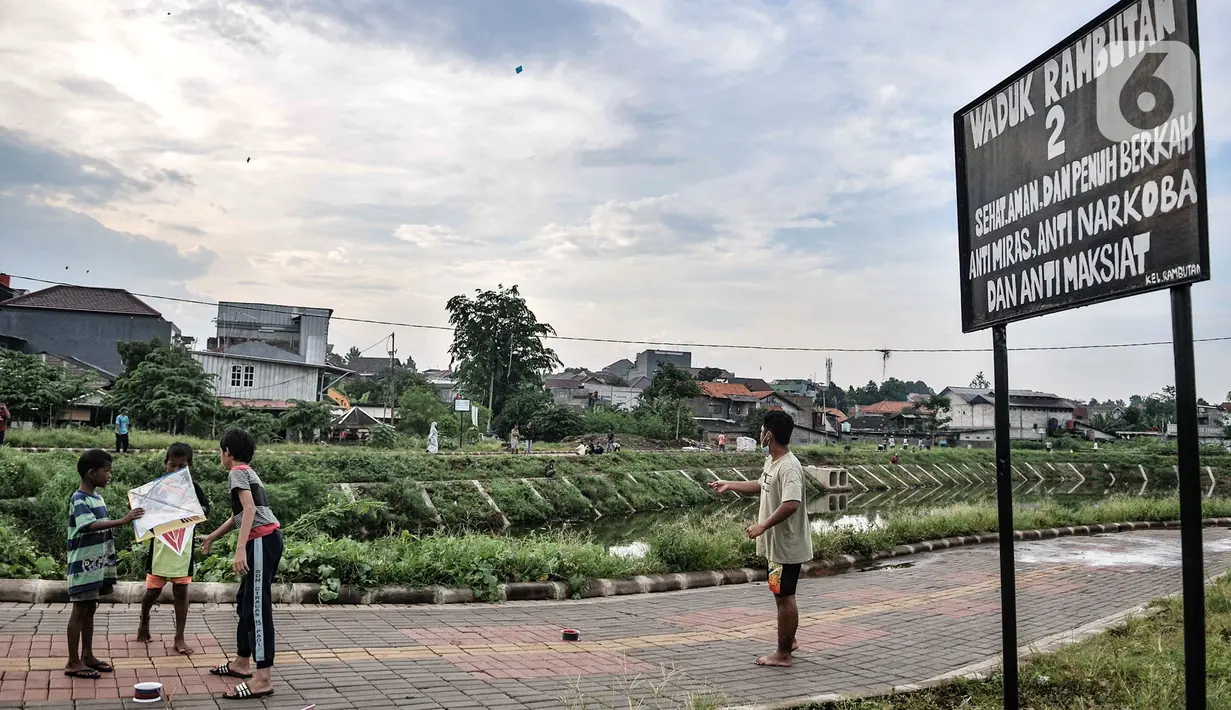 Anak-anak bermain layang di sekitar Waduk Kampung Rambutan 2, Jakarta, Kamis (12/11/2020). Waduk seluas 4,6 hektare yang rampung dibangun oleh Pemprov DKI pada 2019 tersebut kini menjadi lokasi wisata alternatif bagi warga setempat, terlebih saat pandemi Covid-19.  (merdeka.com/Iqbal S. Nugroho)