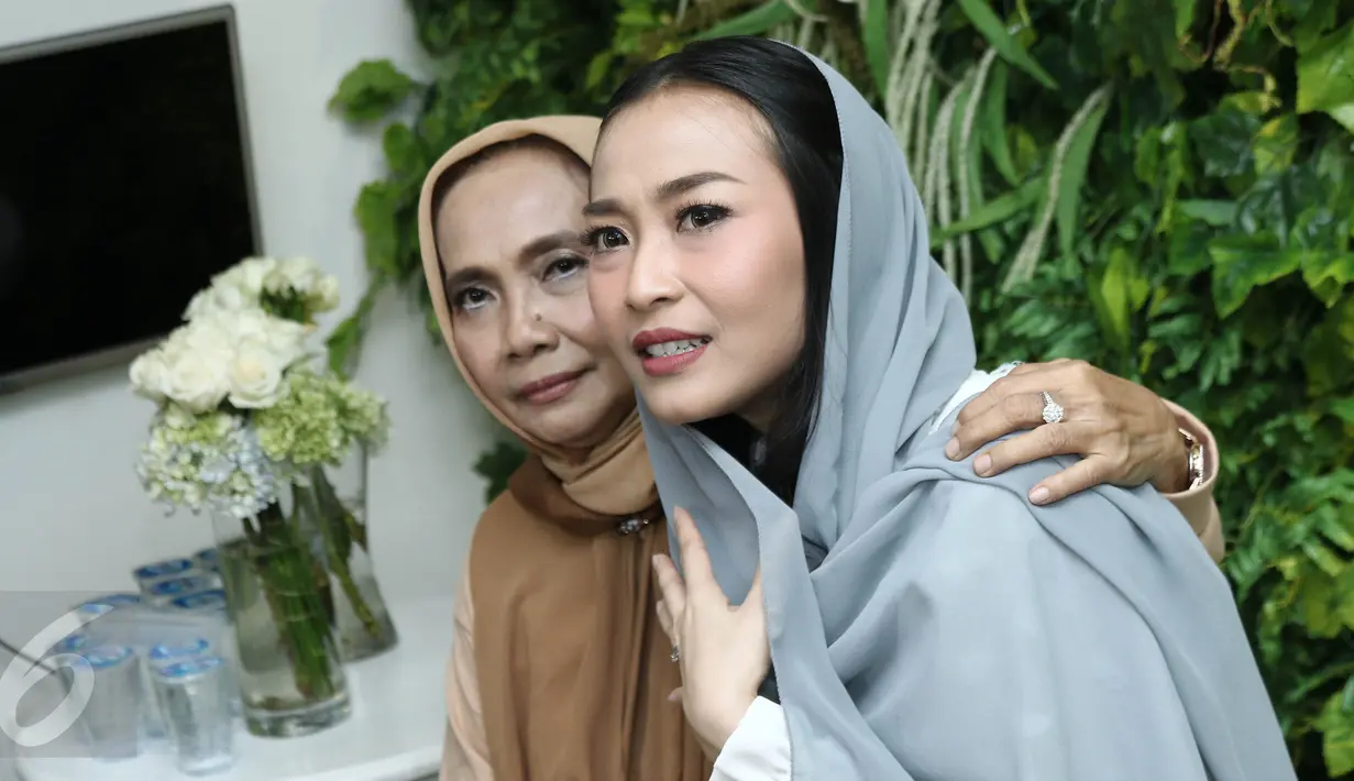 Penyanyi Rinni Wulandari bersama ibunya berpose saat  jumpa pers seusai menggelar pengajian dalam perayaan hari ulang tahun dan menjelang pernikahan di kawasan Cireundeu, Tangerang Selatan, Jumat (28/4). (Liputan6.com/Herman Zakharia)