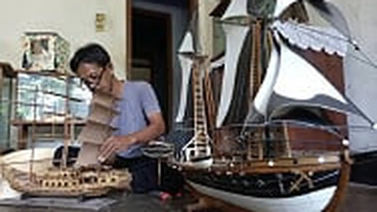 Perajin, Iping, sedang membuat miniatur perahu khas Purwakarta. (Foto: Liputan6.com/Asmul)