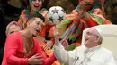 Paus Fransiskus memutar bola di jari saat kelompok sirkus Kuba tampil dalam audiensi umum mingguan di Vatikan, Rabu (2/1). Paus mengucapkan terima kasih kepada para anggota sirkus atas penampilan menghibur mereka. (AP Photo/Andrew Medichini)