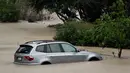 Sebuah mobil terendam di dekat Sungai Rusia yang meluap dan menyebabkan di Guerneville, California, AS, Selasa (10/1). Cuaca ektrem "Pineapple Express" yang membawa kelembapan dari Hawaii menciptakan hujan badai. (AP Photo / Eric Risberg)