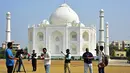Dalam foto pada 25 November 2021, awak media berdiri di depan replika Taj Mahal di Burhanpur di negara bagian Madhya Pradesh, India. Pengusaha India Anand Prakash Chouksey membangun replika Taj Mahal untuk istrinya dengan biaya hingga sekitar Rp 2,6 miliar. (Uma Shankar MISHRA / AFP)