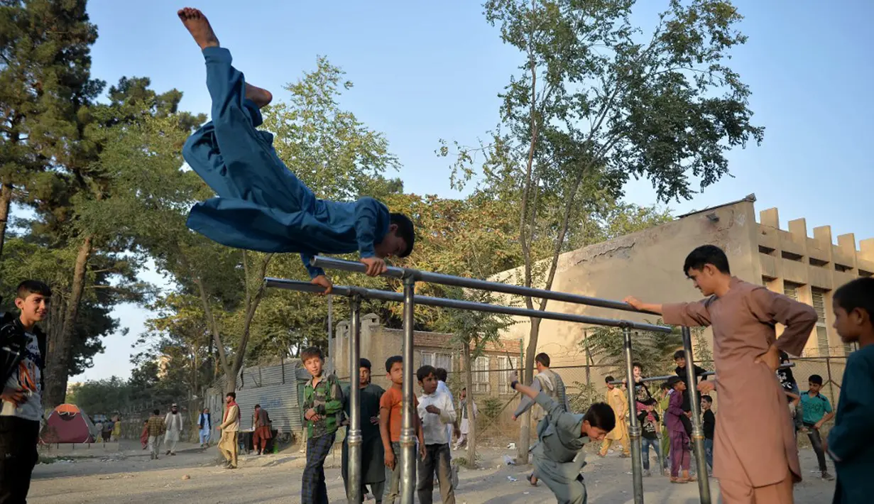 Anak-anak bermain pada palang besi yang terpasang di Shahr-e Naw Park, Kabul, Afghanistan, 9 September 2021. Taliban menguasai Afghanistan setelah pasukan Amerika Serikat meninggalkan negara tersebut. (HOSHANG HASHIMI/AFP)