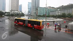Bus Transjakarta melintas di kawasan Car Free Day, Jakarta, Minggu (28/2/2016). Hujan yang mengguyur Ibukota sejak semalam hingga pagi membuat kawasan CFD sepi pengunjung. (Liputan6.com/Immanuel Antonius)