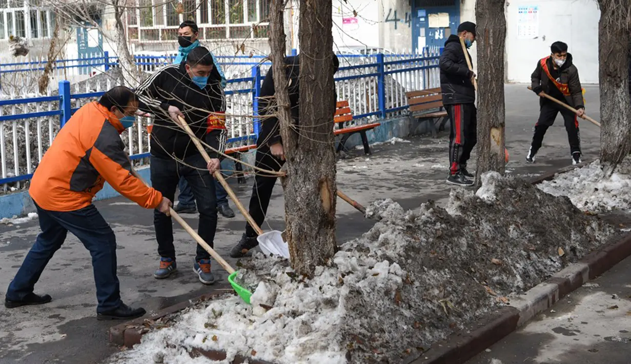 Petugas dan warga membersihkan salju di Urumqi, Daerah Otonomi Xinjiang, China barat laut, Rabu (4/3/2020). Urumqi mengampanyekan sanitasi di seluruh kota guna mencegah penyebaran virus corona (COVID-19). (Xinhua/Ding Lei)