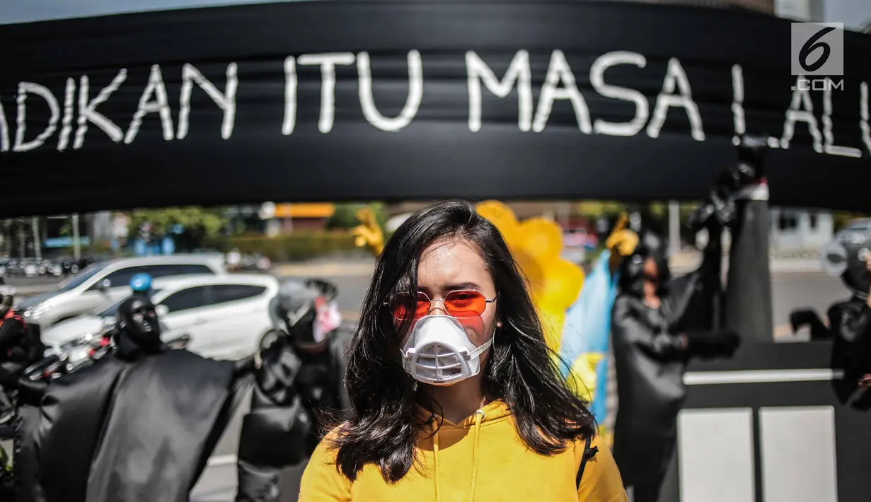 Massa aksi yang tergabung dalam gerakan masyarakat non partisan #BersihkanIndonesia menggenakan masker saat aksi teatrikal di lintasan penyeberangan orang atau Pelican crossing di Jakarta, Kamis (20/12). (Liputan6.com/Faizal Fanani)