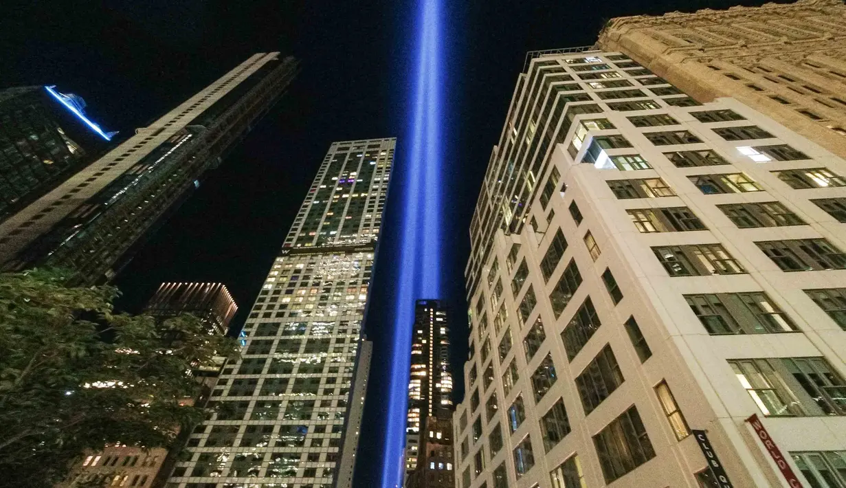 Tribute in Light tahunan memproyeksikan dua pilar cahaya ke langit malam di samping gedung-gedung yang menghadap ke 9/11 Memorial & Museum di New York City (10/9/2021). Dua cahaya kembar yang dikenal dengan Tribute in Light menyinari langit Kota New York. (AFP/Roberto Schmidt)