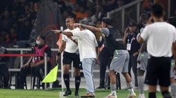 Pelatih Persebaya Surabaya, Aji Santoso (dua kiri), keluar dari teknikal area dan melakukan protes kepada asisten wasit dikarenakan bola umpang pemain Persebaya yang disundul oleh pemain Persija dan keluar dari lapangan tersebut tidak digubris oleh asisten wasit. (Bola.com/Ikhwan Yanuar)