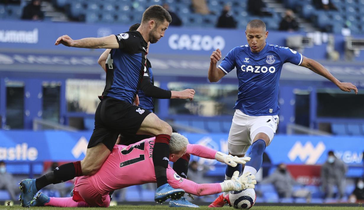 Kiper Crystal Palace, Vicente Guaita (tengah) berhasil menangkap bola dari ancaman striker Everton, Richarlison dalam laga lanjutan Liga Inggris 2020/2021 pekan ke-30 di Goodison Park, Liverpool, Senin (5/4/2021). Crystal Palace bermain imbang 1-1 dengan Everton. (AP/Clive Brunskill/Pool)