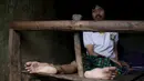 Seorang pria yang menderita penyakit mental duduk dirantai di tempat tidur kamarnya di dalam rumah keluarganya di Curug Sulanjana Desa penginapan Serang, Provinsi Banten, Indonesia (23/3). (REUTERS/Beawiharta)