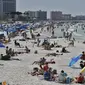 Pengunjung menikmati Clearwater Beach di Florida, Amerika Serikat, Rabu (18/3/2020). Para pengunjung diminta menjaga jarak satu sama lain untuk mengurangi risiko penyebaran virus corona COVID-19. (AP Photo/Chris O'Meara)