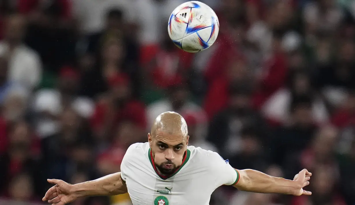 <p>Gelandang Maroko, Sofyan Amrabat menyundul bola saat bertanding melawan Kanada pada pertandingan grup F Piala Dunia 2022 di Stadion Al Thumama di Doha, Qatar, Kamis (1/12/2022). Hasil ini membuat Maroko lolos ke babak 16 besar Piala Dunia 2022 dengan status juara Grup F dengan perolehan tujuh poin. Sementara runner up jadi milik Kroasia. (AP Photo/Manu Fernandez)</p>