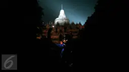 Seorang wisatawan menyalakan lilin dengan latar belakang Candi Borobudur saat dilaksanakan program Earth Hour atau peringatan Hari Bumi oleh WWF, UNESCO dan Balai Konservasi Borobudur, Magelang, Jawa Tengah, Sabtu (19/3) malam. (Foto: Boy Harjanto)
