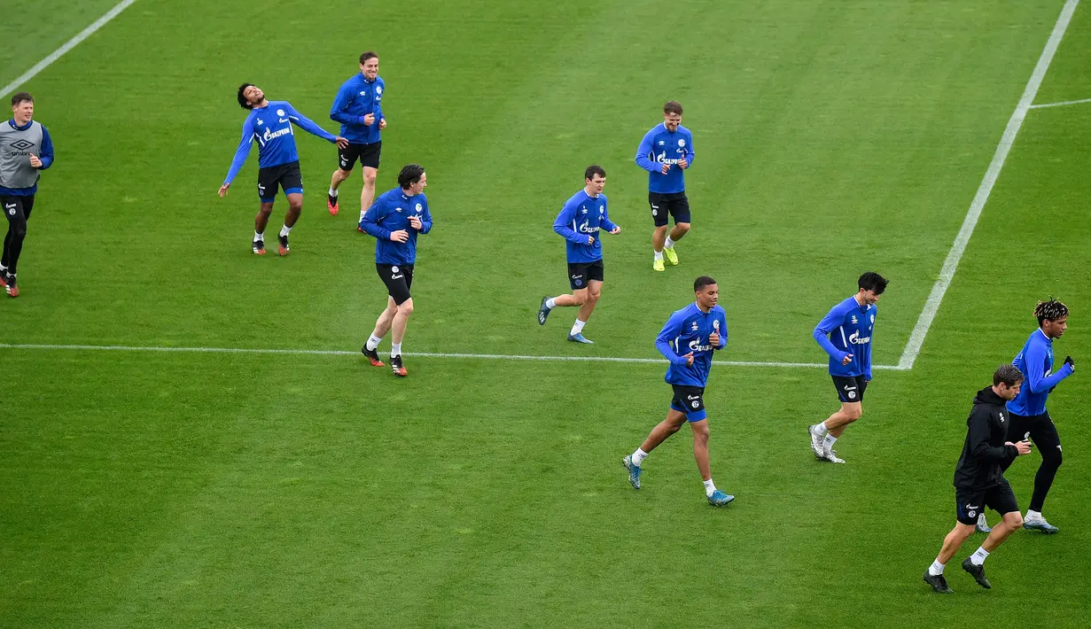 Pemain FC Schalke 04 melakukan pemanasan selama sesi pelatihan di Gelsenkirchen, Jerman, Rabu, (29/4/2020). Meski ada larangan pertemuan besar hingga Agustus untuk melawan pandemi Covid-19, para pejabat sepakbola berharap untuk memulai kembali liga tanpa penonton di bulan Mei. (AP/Martin Meissner)