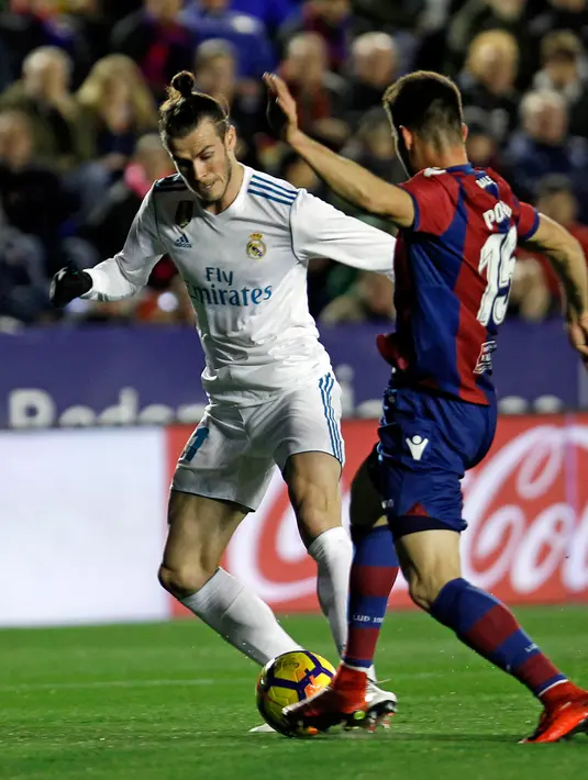 Pemain Real Madrid Gareth Bale berusaha melewati pemain Levante Sergio Postigo saat pertandingan Liga Spanyol di stadion Ciutat de Valencia di Valencia (3/2). (AP Photo/Alberto Saiz)