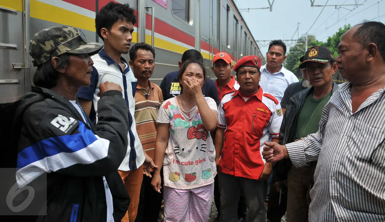 Seorang warga memberikan kesaksian atas terjadinya kecelakaan maut antara Metromini dengan Kereta di perlintasan Angke, Tambora, Jakarta, Minggu (6/12/2015). Sebanyak 13 orang dilaporkan tewas. (Liputan6.com/Gempur M Surya)  