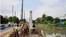 Sejumlah pekerja tengah menggarap proyek pembangunan turap Kali Utan Kayu, Jakarta, Selasa (17/6/14). (Liputan6.com/Faizal Fanani)