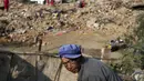 Salah satu korban melintasi puing-puing rumah yang hancur akibat gempa di Longtoushan, provinsi Yunan, Tiongkok, (6/8/2014). (REUTERS/Stringer)