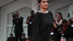 Adriana Lima memamerkan baby bump yang semakin membesar dalam balutan gaun glamor saat ia berjalan di karpet merah The Killer di Festival Film Venesia ke-80 di Italia. (Photo by Tiziana FABI / AFP)