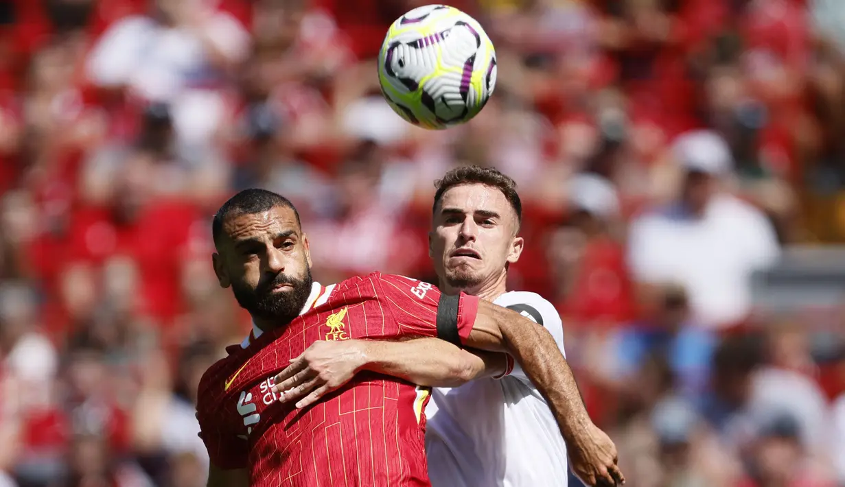 Pemain Liverpool, Mohamed Salah (kiri) berebut bola dengan pemain Sevilla, Adria Pedrosa pada laga persahabatan yang berlangsung di Anfield, Liverpool, Inggris, Minggu (11/08/2024) WIB. (AP Photo/Richard Sellers)
