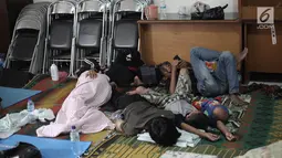 Sejumlah pengungsi banjir tertidur saat mengungsi di Kelurahan Kampung Melayu, Jatinegara, Jakarta Timur, Rabu (7/2). Puluhan KK mengungsi di tempat tersebut. (Liputan6.com/Arya Manggala)