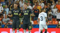 Pemain Juventus, Cristiano Ronaldo bereaksi di sebelah rekan setimnya, Federico Bernardeschi setelah menerima kartu merah saat melawan Valencia pada matchday pertama Grup H Liga Champions, di Stadion Mestalla, Rabu (19/9). (JAVIER SORIANO/AFP)