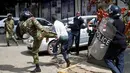 Polisi berusaha menendang demonstran saat bentrokan di Nairobi, Kenya (16/5). Demonstran menuntut pembubaran otoritas pemilu karena adanya dugaan korupsi. (REUTERS/Goran (REUTERS/Goran Tomasevic)