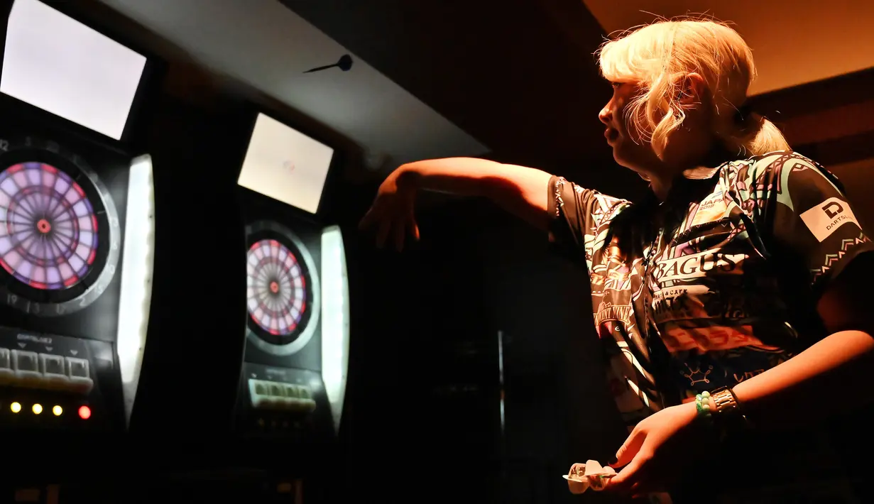 Mikuru Suzuki melempar anak panah saat bermain darts di Tokyo, Jepang, 8 April 2019. Nama Mikuru Suzuki mulai mencuri perhatian setelah memenangkan kejuaraan dunia darts BDO pada Januari lalu. (CHARLY TRIBALLEAU/AFP)