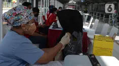 Tenaga kesehatan menyuntikkan cairan vaksin ke penumpang KRL Commterline serta  masyarakat umum  di Stasiun Kota, Jakarta, Rabu (28/7/2021). Vaksinasi disediakan 300 dosis bagi penumpang dan masyarakat umum guna menekan penyebaran Covid-19.  (merdeka.comm/Imam Buhori)