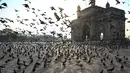 Merpati terbang di daerah terpencil di depan Gerbang India selama pembatasan yang diberlakukan oleh pemerintah negara bagian di tengah meningkatnya kasus corona Covid-19, di Mumbai, Kamis (15/4/2021). Kasus virus corona di India mencapai rekor tertinggi pada Rabu, 14 April. (Punit PARANJPE / AFP)