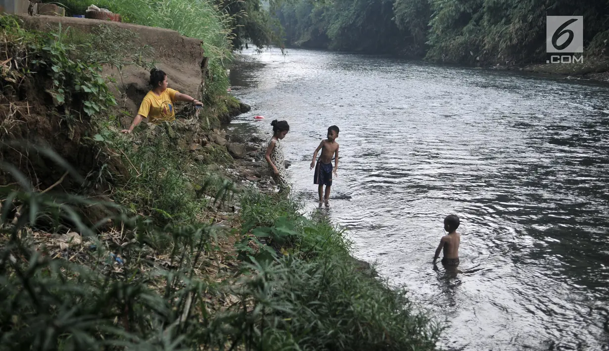 Sejumlah anak bermain di Sungai Ciliwung, Depok, Jawa Barat, Kamis (4/7/2019). Menurunnya debit air Sungai Ciliwung akibat musim kemarau dimanfaatkan warga setempat sebagai tempat wisata gratis untuk mengajak anak berenang. (merdeka.com/Iqbal Nugroho)