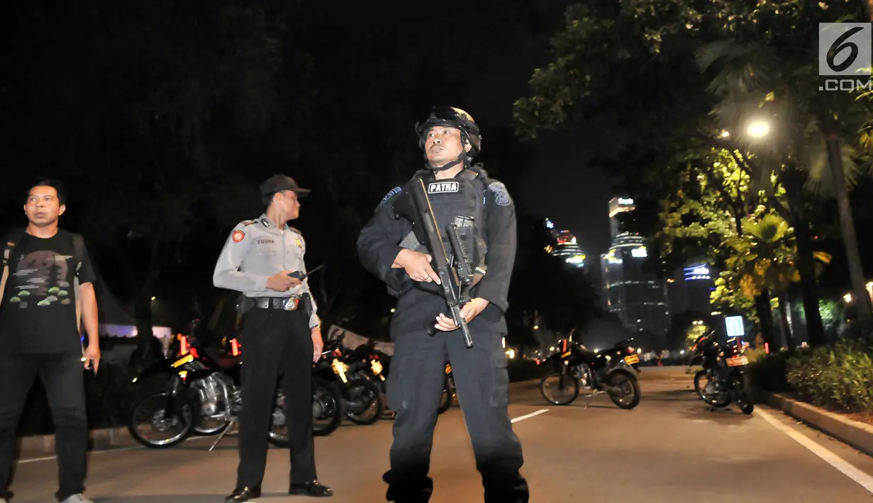 Polisi bersenjata laras berjaga tidak jauh dari lokasi ledakan di Parkir Timur Stadion Gelora Bung Karno (GBK), Jakarta, Minggu (17/2). Ledakan terjadi di dekat lokasi nonton bareng yang disediakan untuk pendukung capres. (merdeka.com/Iqbal S Nugroho)