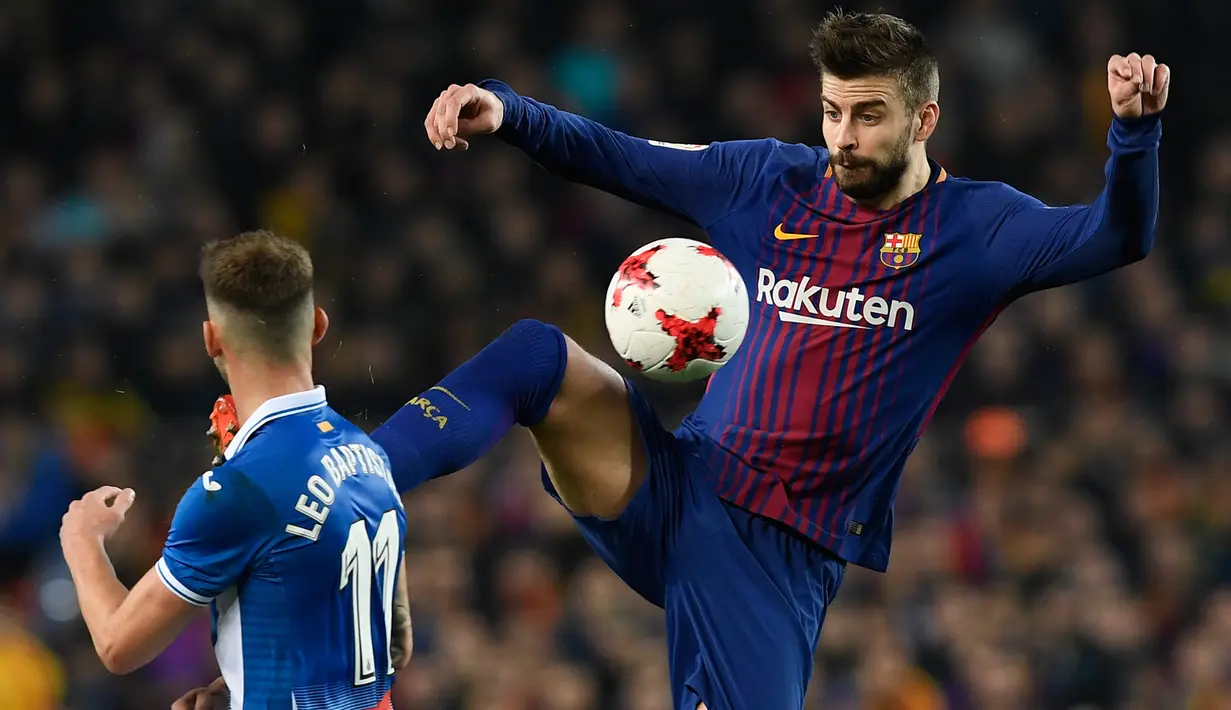 Pemain Barcelona, Gerard Pique berebut bola dengan pemain Espanyol, Leo Baptistao pada laga leg kedua perempat final Copa del Rey di Camp Nou, Kamis (25/1). Tiket semifinal berhasil diraih Barcelona usai mengalahkan Espanyol 2-0. (AFP PHOTO/LLUIS GENE)