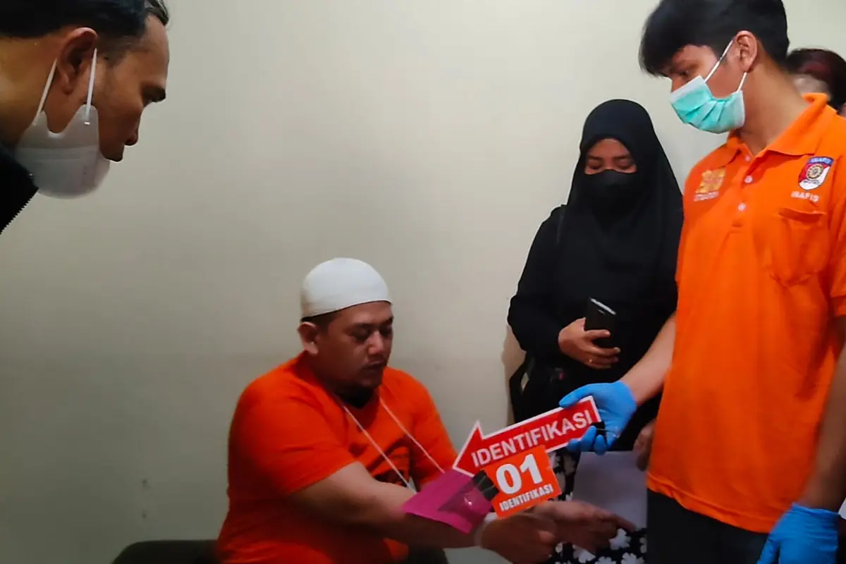 Rekontruksi pembunuhan yang dilakukan tersangka kepada anak kandungnya di Perumahan Jatijajar, Kecamatan Tapos, Kota Depok.