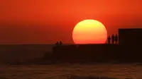 Sejumlah orang menyaksikan matahari terbenam di pantai El Tunco di La Libertad, 34 km sebelah selatan dari San Salvador, pada 5 Maret 2017. San Salvador adalah ibu kota sekaligus kota terbesar El Salvador.  (AFP Photo / Marvin Recinos)