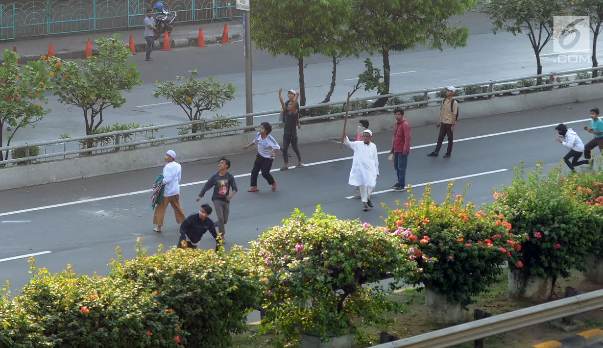Massa melempar batu ke arah petugas kepolisian dari jalan tol dalam kota saat bentrok massa di kawasan Slipi, Jakarta, Rabu (22/5/2019). Jalan tol dalam kota sempat ditutup sekitar setengah jam, dan massa dihalau petugas ke arah kemanggisan. (merdeka.com/Arie Basuki)