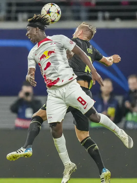 Gelandang RB Leipzig  Amadou Haidara menyundul bola dengan gelandang Real Madrid Toni Kroos pada pekan ke-5 Grup F Liga Champions 2022/2023 di Red Bull Arena, Rabu (26/10/2022) dinihari WIB. Hasil ini membuat peluang Real Madrid menjadi juara grup F Liga Champions menipis. (AP Photo/Matthias Schrader)