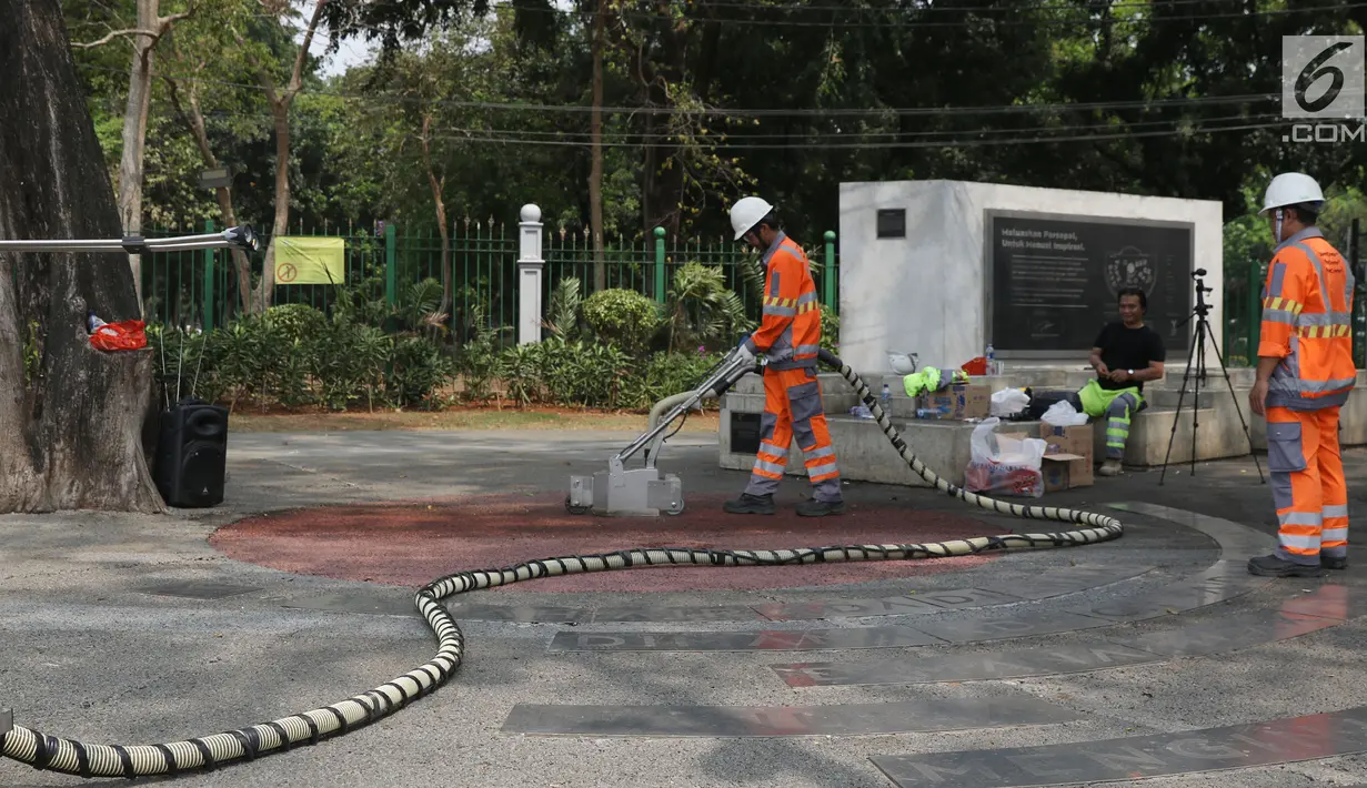 Petugas menggunakan alat ThruKlin untuk membersihkan beton berpori di area Taman Pandang Istana, Jakarta, Kamis (2/8). Beton berpori digunakan pada beberapa proyek revitalisasi, salah satunya kawasan SUGBK. (Liputan6.com/Helmi Fithriansyah)