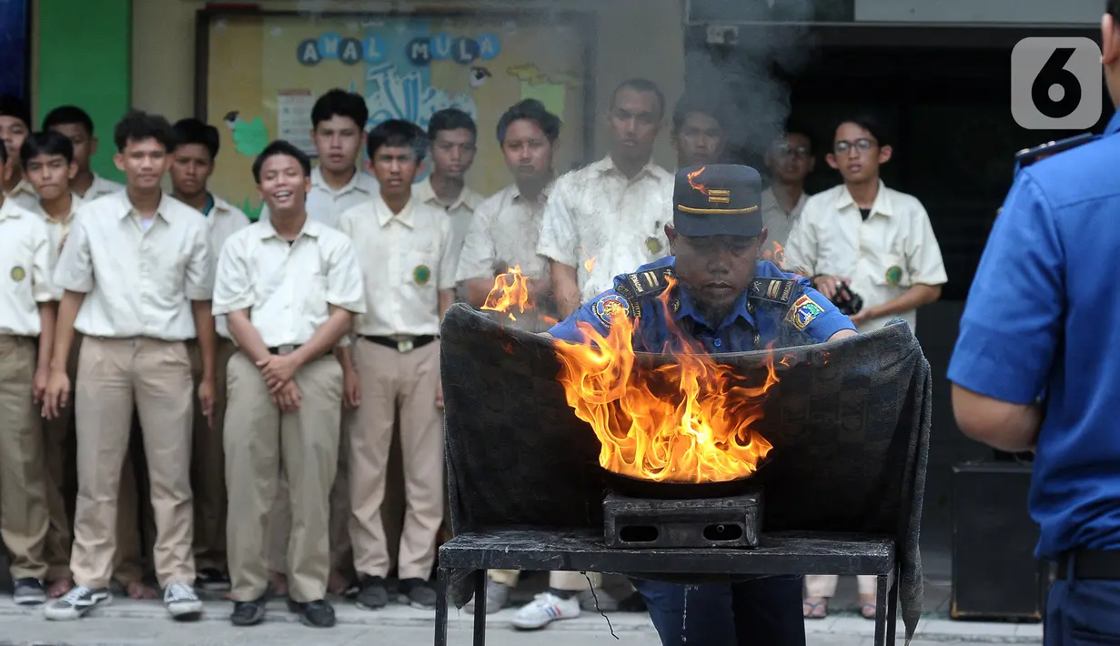 Petugas Badan Penanggulangan Bencana Daerah (BPBD) DKI Jakarta bersama Pemadam Kebakaran DKI Jakarta melakukan pelatihan tanggap bencana dan kebakaran di Madrasah Aliyah Swasta Persatuan Islam (MAS Persis) 69, Matraman, Jakarta, Selasa (19/9/2023). (merdeka.com/Imam Buhori)