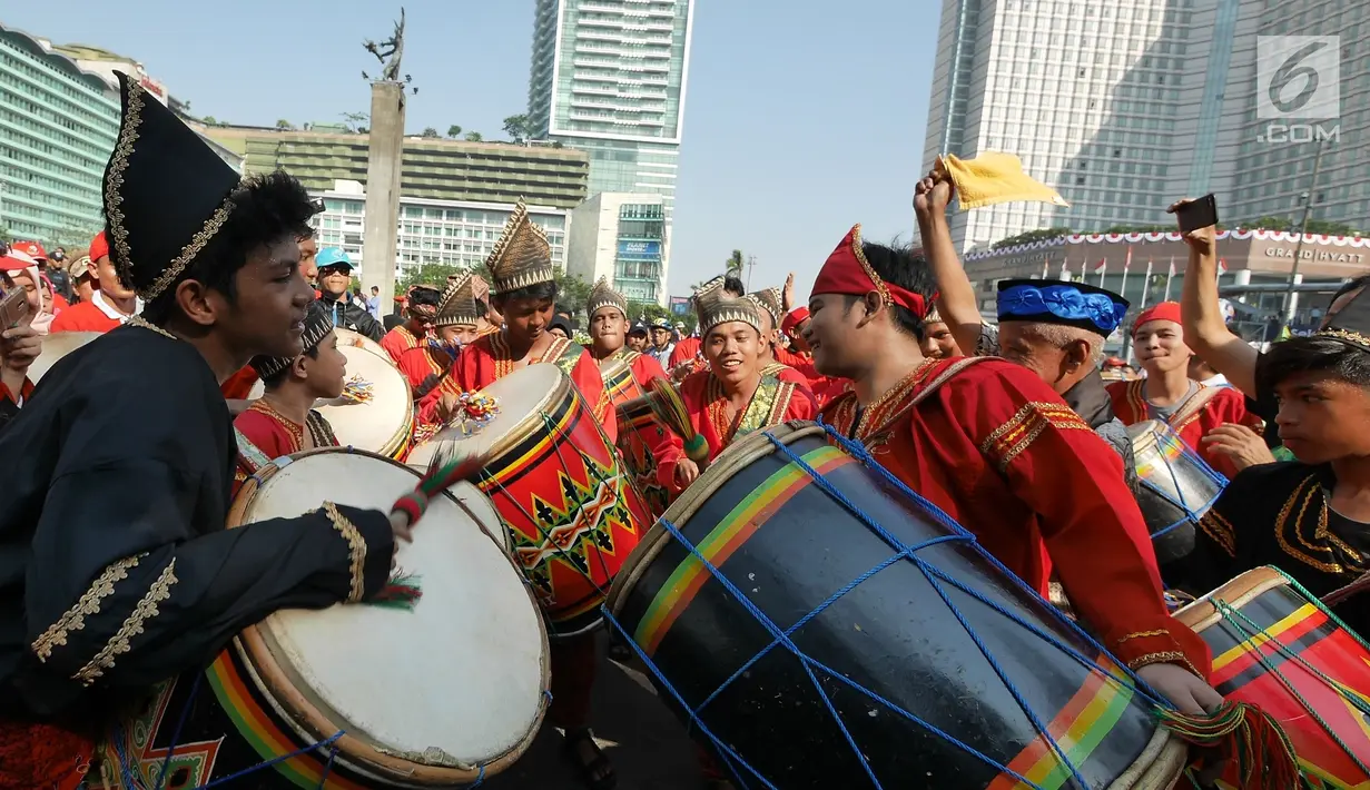 Masyarakat Maninjau Sumatera Barat memainkan Tambua Tansa di areal car free day (CFD), Jakarta, Minggu (8/7). Parade Tambua Tansa Minangkabau ini mengawali rangkaian Festival Danau Maninjau pada Oktober 2018 mendatang. (Liputan6.com/Herman Zakharia)