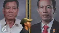 Warga melintas di depan foto Jokowi dan Duterte di Taman Pandang Istana, Jakarta, Kamis (8/9). Rencananya Duterte akan berkunjung ke Indonesia pada Jumat (9/9). (Liputan6.com/Immanuel Antonius)