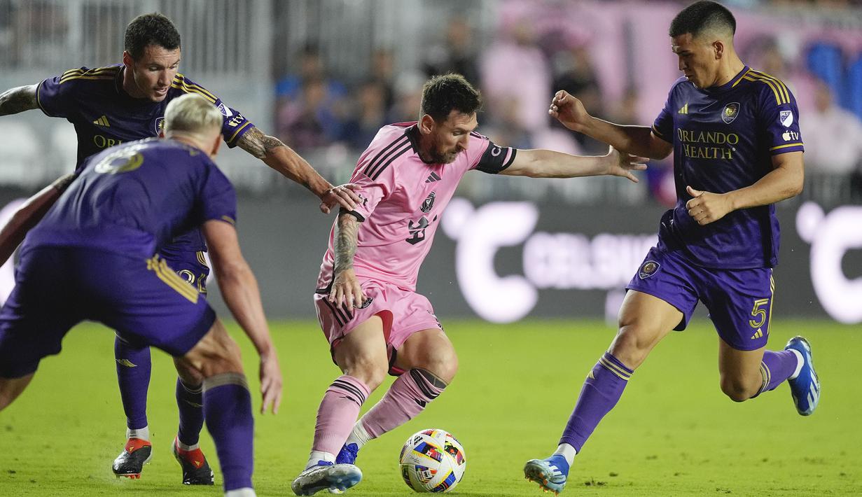 Pemain Inter Miami, Lionel Messi (tengah) berusaha melewati sejumlah penjagaan pemain Orlando City pada laga lanjutan Major League Soccer (MLS) 2024 yang berlangsung di Chase Stadium, Fort Lauderdale, Florida, Minggu (03/03/2024) WIB. The Herons menang dengan skor 5-0. (AP Photo/Rebecca Blackwell)