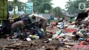 Warga memilah sampah sisa banjir di bawah Tol Becakayu, Cipinang Melayu, Jakarta Timur, Rabu (8/1/2020). Sampah sisa banjir tersebut selanjutnya dibawa petugas PPSU ke TPA Bantar Gebang. (merdeka.com/Magang/Muhammad Fayyadh)